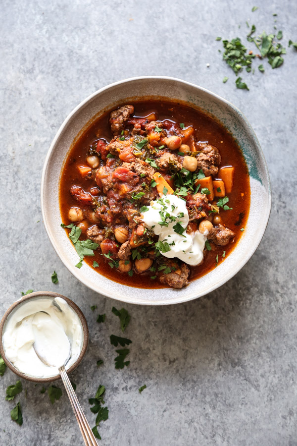 ground lamb chili in a bowl with yogurt garnish on the side