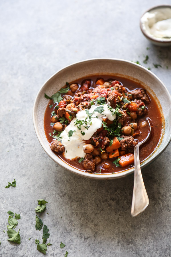 spoonful of moroccan ground lamb chili in a bowl with yogurt on top